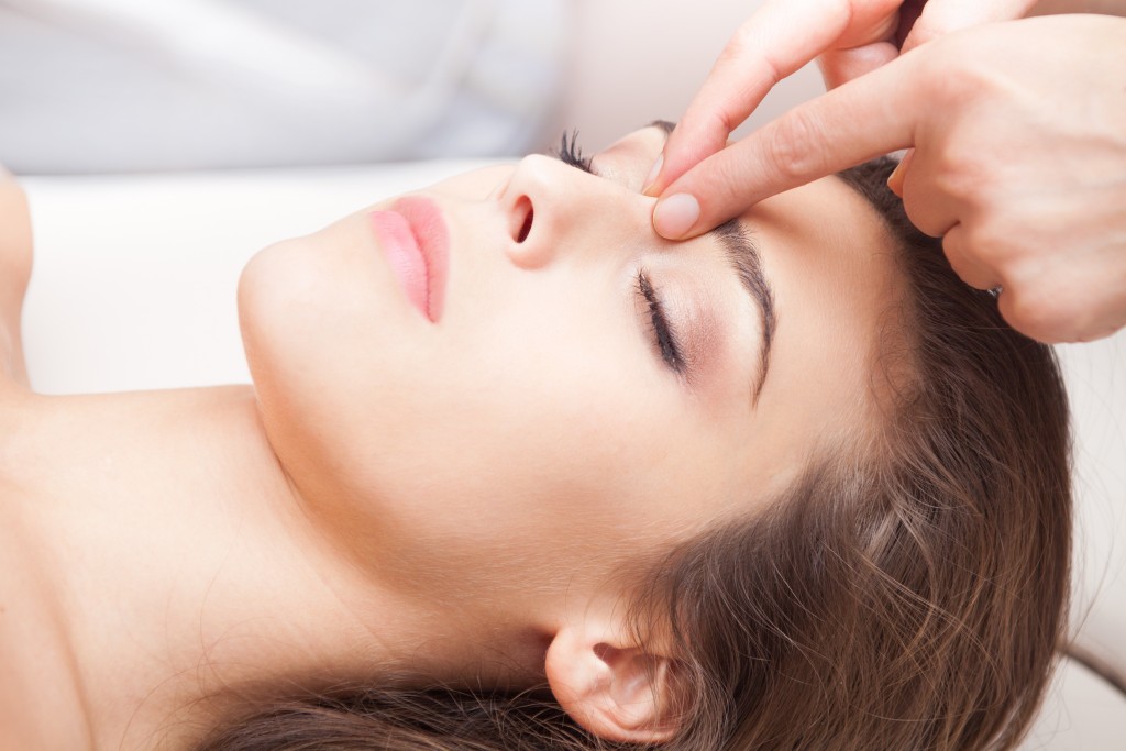 woman acupressure face massage closeup
